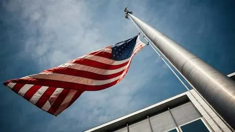 The American flag blows in the wind on a cloudy day